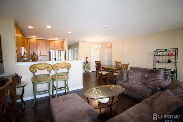 living area with a chandelier, recessed lighting, dark wood finished floors, and baseboards