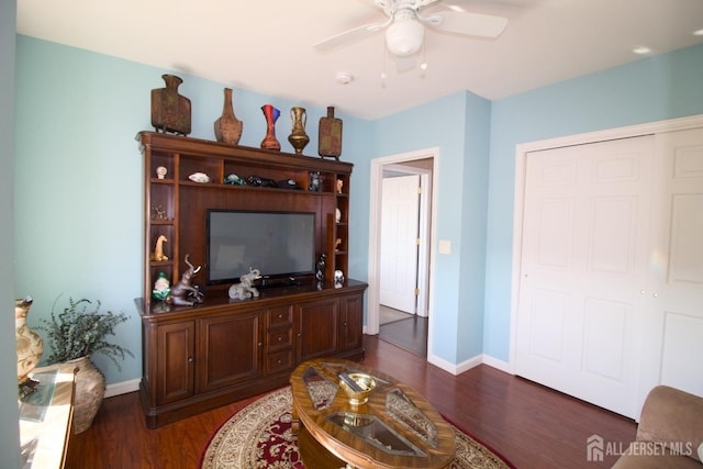 living area featuring a ceiling fan, dark wood-style floors, and baseboards