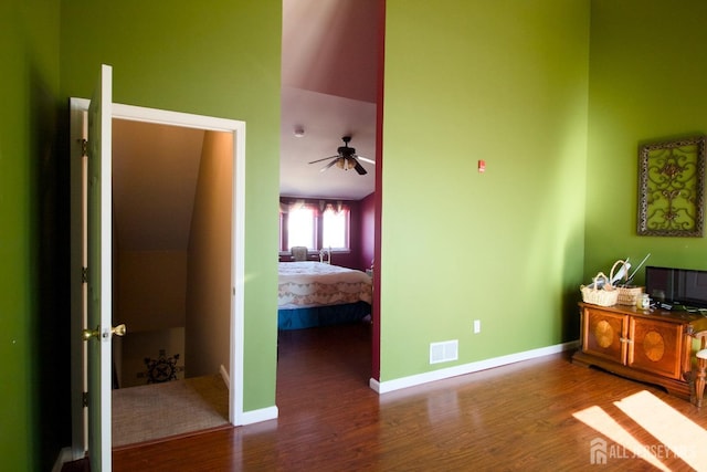 bedroom with baseboards, wood finished floors, and visible vents