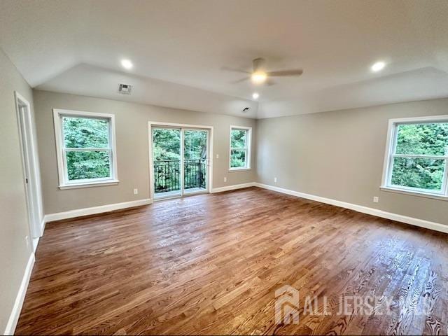 unfurnished room with ceiling fan, vaulted ceiling, dark hardwood / wood-style floors, and a healthy amount of sunlight