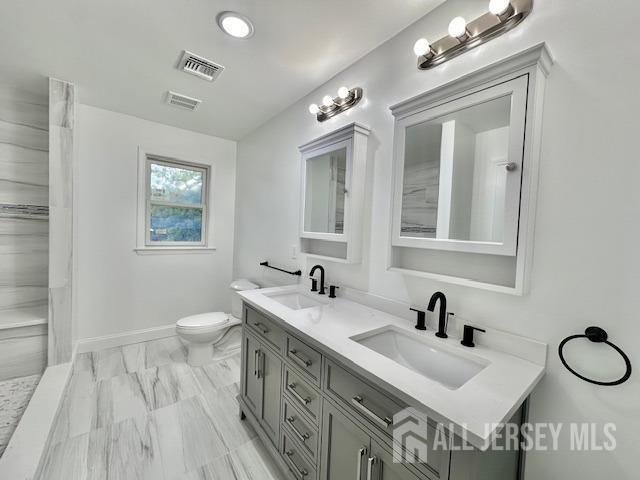 bathroom featuring vanity and toilet