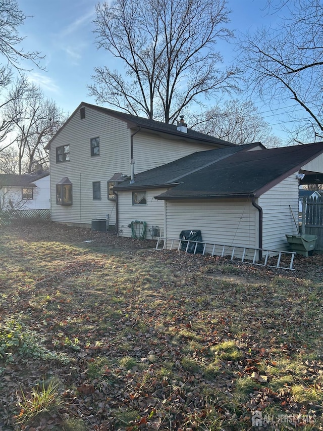 view of property exterior with central AC unit and a chimney