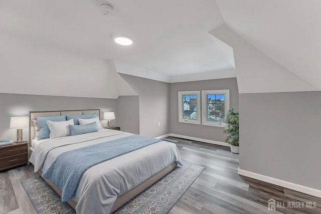 bedroom with lofted ceiling and wood-type flooring