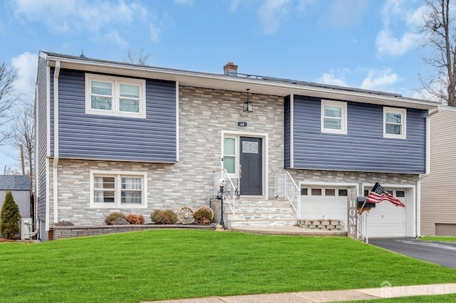 split foyer home with a front yard and a garage