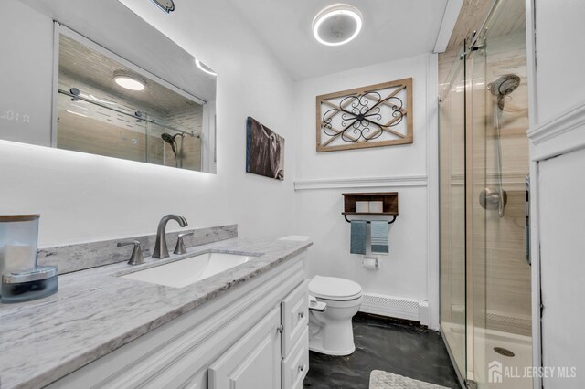 bathroom with a shower with door, a baseboard radiator, vanity, and toilet