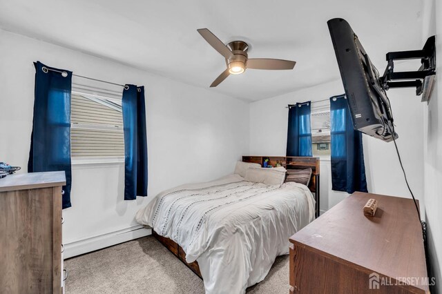 bedroom featuring a baseboard heating unit, ceiling fan, and light colored carpet