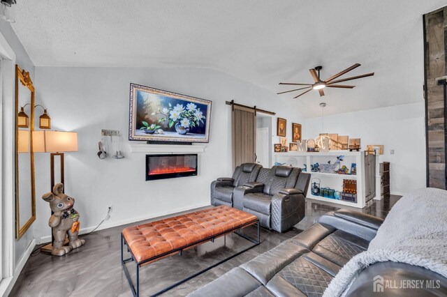 living room featuring ceiling fan, vaulted ceiling, and a barn door