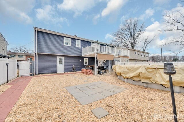 back of house with a balcony and a patio