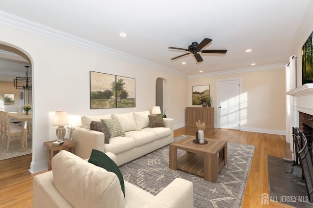 living room with hardwood / wood-style flooring, ornamental molding, and ceiling fan