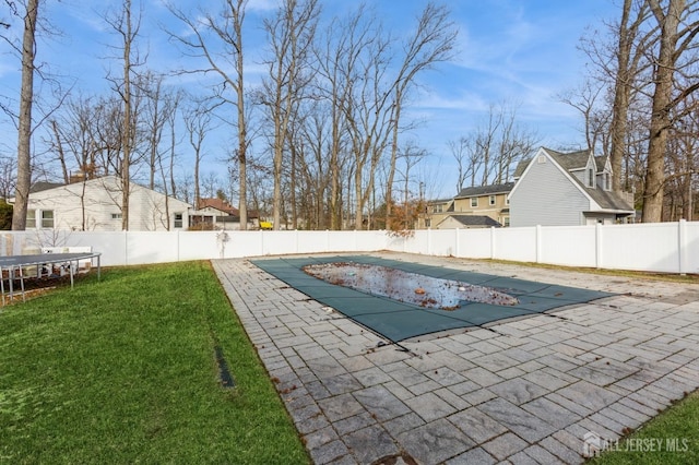 view of pool with a patio, a trampoline, and a lawn