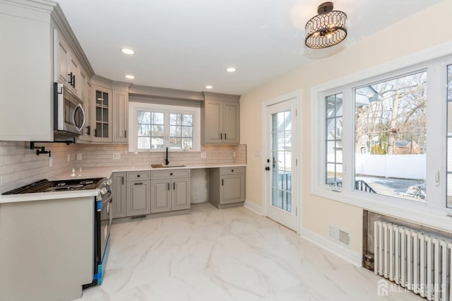 kitchen featuring stainless steel appliances, sink, gray cabinetry, and radiator heating unit