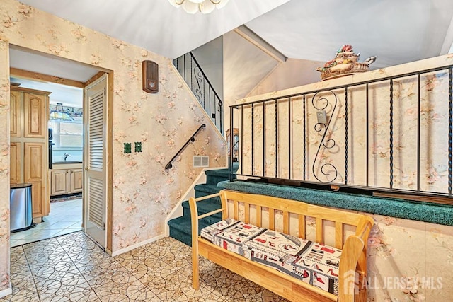 stairway featuring lofted ceiling and sink