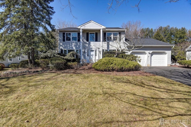 greek revival inspired property featuring driveway, a front yard, and a garage