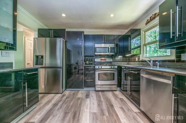 350 Church Ln, North Brunswick, NJ 08902 - kitchen featuring stainless steel appliances, a sink, crown molding, green cabinetry, and tasteful backsplash