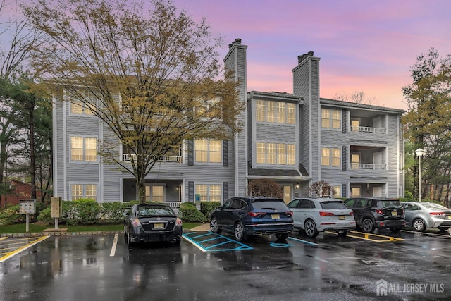 view of building exterior with uncovered parking