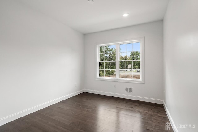 spare room with dark wood-type flooring