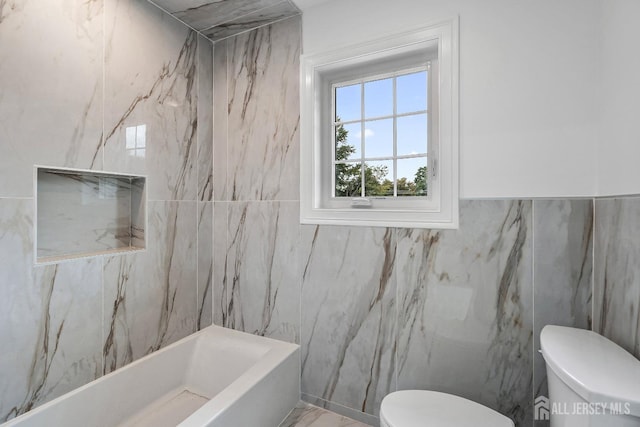 bathroom with toilet, tile walls, and a tub