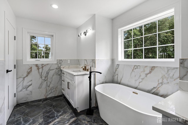 bathroom with a bathtub, plenty of natural light, and vanity