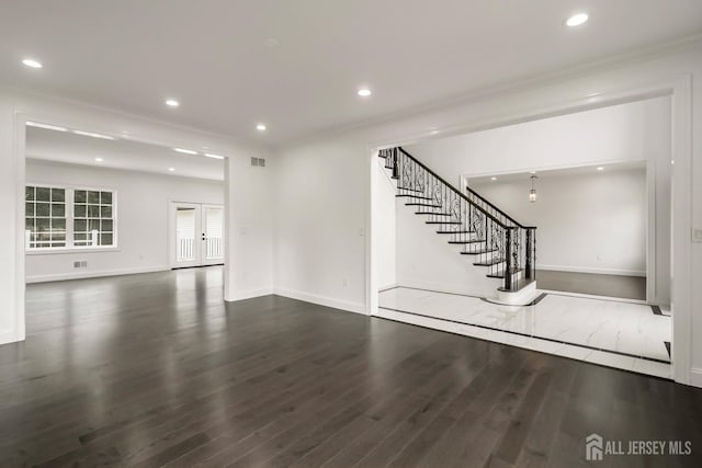 unfurnished living room featuring dark hardwood / wood-style floors and crown molding