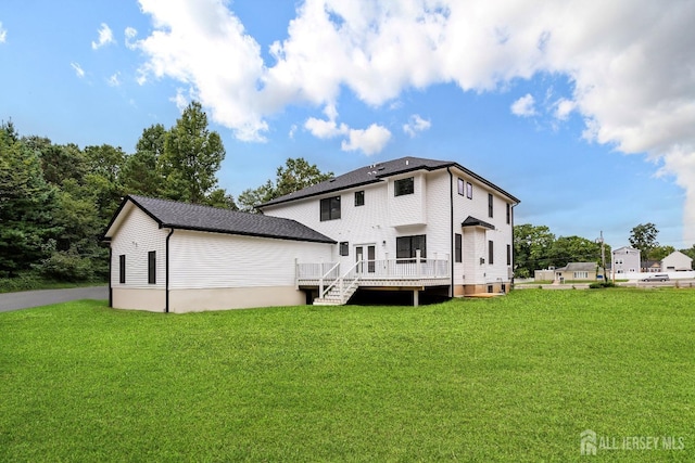 rear view of property with a lawn and a deck