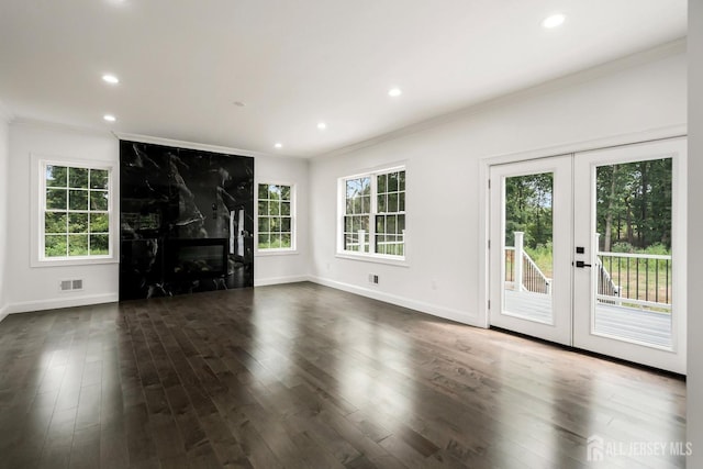 unfurnished living room with dark hardwood / wood-style flooring, french doors, a high end fireplace, and ornamental molding