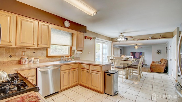kitchen featuring stainless steel dishwasher, light countertops, a ceiling fan, a sink, and light tile patterned floors