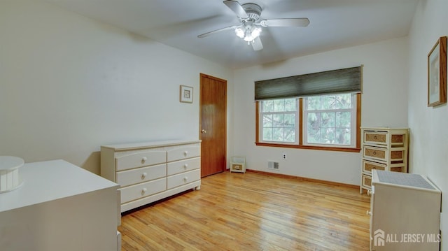 unfurnished bedroom featuring light wood-style floors, baseboards, and a ceiling fan