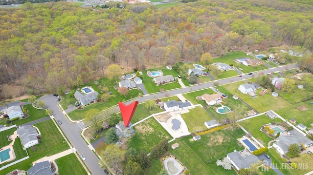 aerial view of property's location with a forest and nearby suburban area