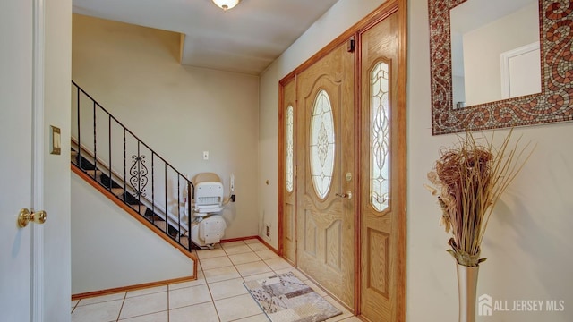 foyer featuring stairs and light tile patterned flooring