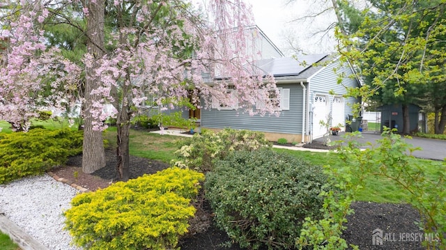 view of home's exterior featuring roof mounted solar panels and an attached garage