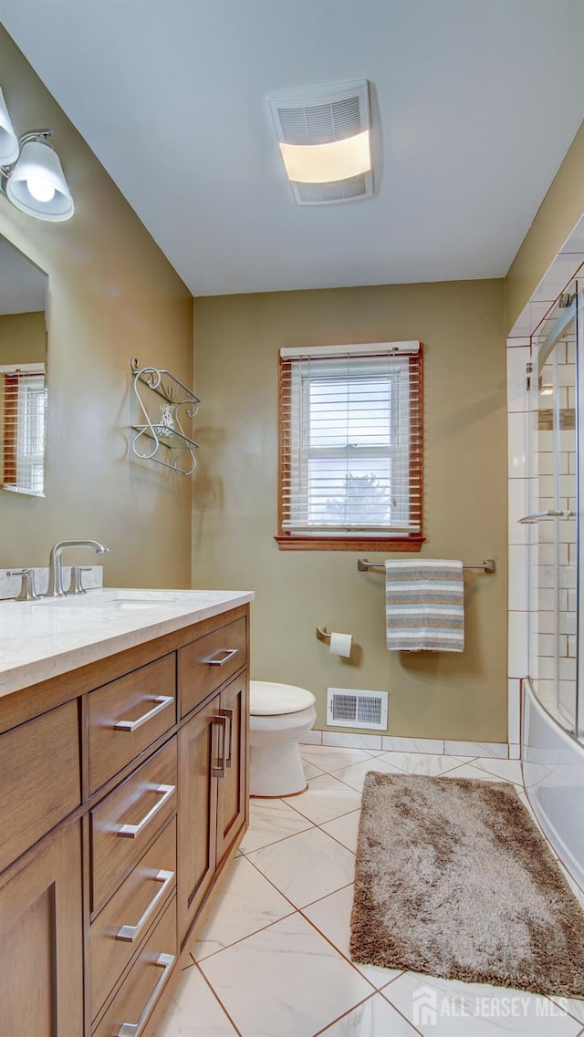 bathroom with vanity, toilet, shower / bath combination with glass door, and tile patterned flooring