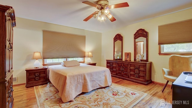 bedroom featuring multiple windows, wood finished floors, and a ceiling fan
