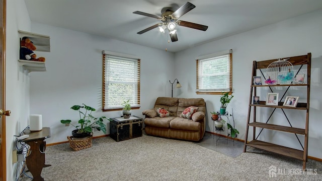 living area with plenty of natural light, a ceiling fan, and carpet