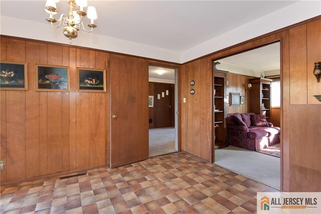 foyer entrance with a notable chandelier and wood walls