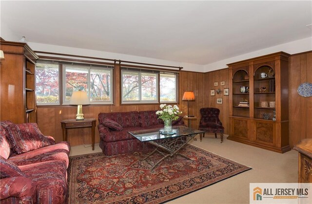 carpeted living room with a wealth of natural light and wood walls