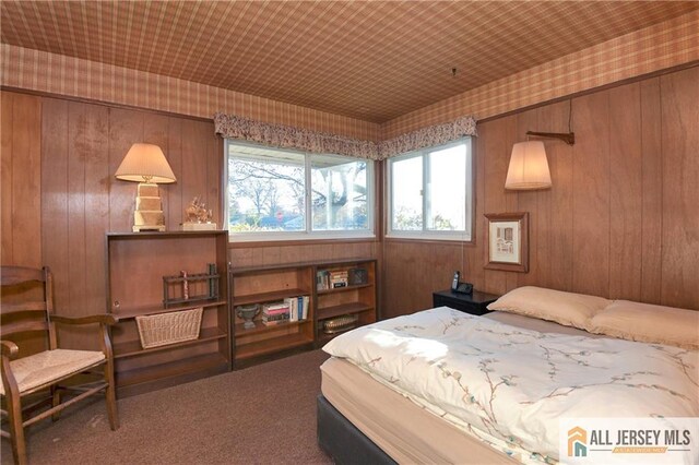 bedroom featuring carpet and wood walls