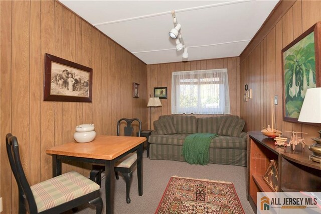 dining room with carpet flooring and wood walls