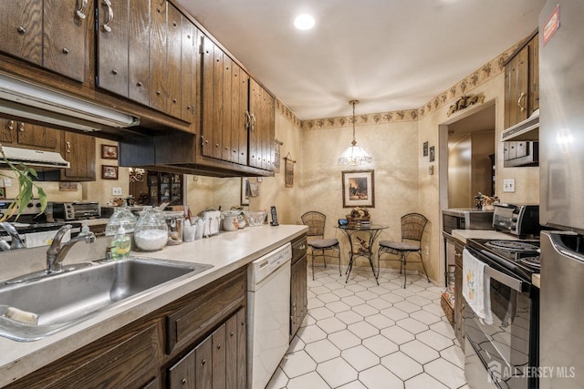 kitchen featuring black range with electric stovetop, a sink, light countertops, dishwasher, and decorative light fixtures