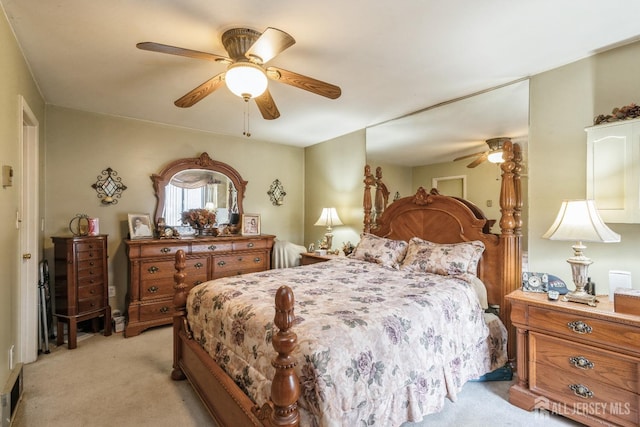 bedroom featuring ceiling fan, visible vents, and light colored carpet