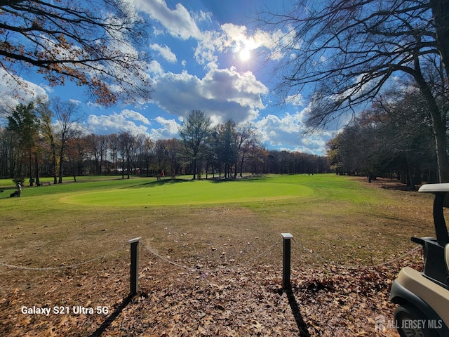 view of home's community with golf course view and a yard