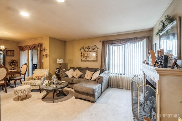 living room featuring recessed lighting, light colored carpet, and a fireplace