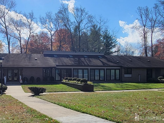 rear view of property with a lawn and french doors