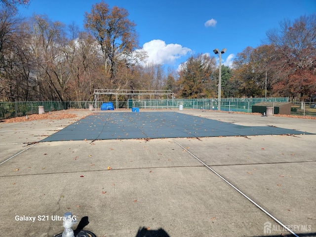 pool with a patio and fence