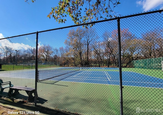 view of tennis court with fence