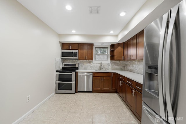 kitchen featuring stainless steel appliances, a sink, visible vents, backsplash, and open shelves