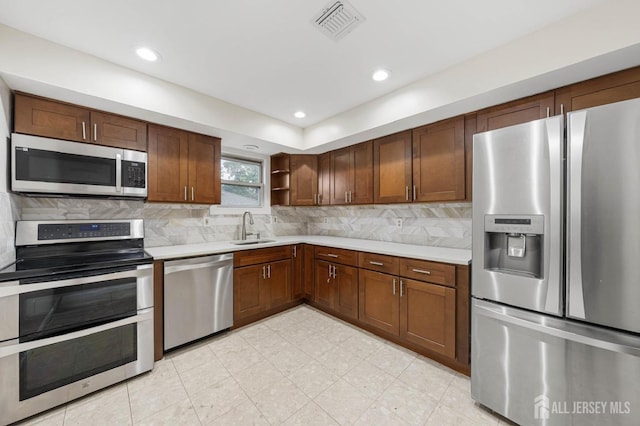 kitchen with stainless steel appliances, open shelves, light countertops, and visible vents