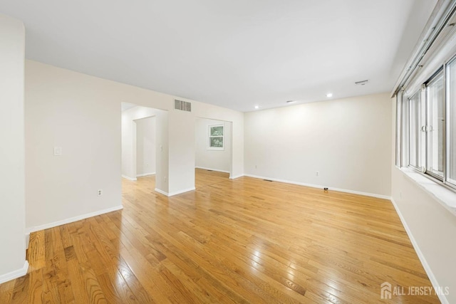 unfurnished room featuring light wood-type flooring, visible vents, baseboards, and recessed lighting