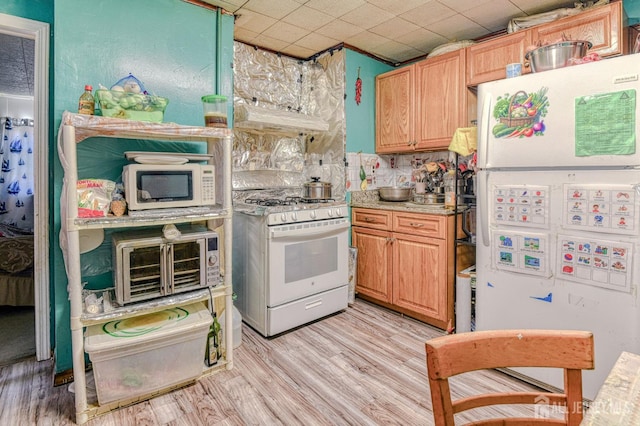 195 Ward St, New Brunswick, NJ 08901 - kitchen featuring white appliances, light countertops, light wood-style floors, and range hood