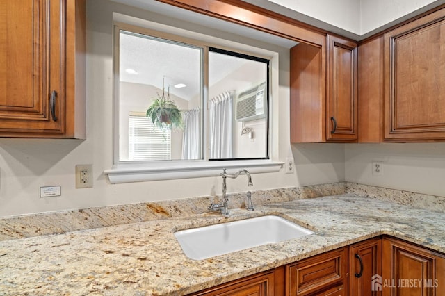 620 Deal Rd Unit 620A, Monroe, NJ 08831 - kitchen with a sink, brown cabinets, light stone counters, an AC wall unit, and vaulted ceiling