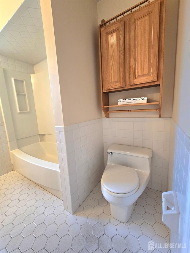 20 Ellingham Ave, Monroe, NJ 08831 - bathroom with tile walls, toilet, a tub to relax in, wainscoting, and tile patterned flooring